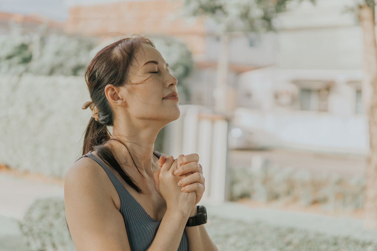 improve your spiritual routine showing woman praying outside