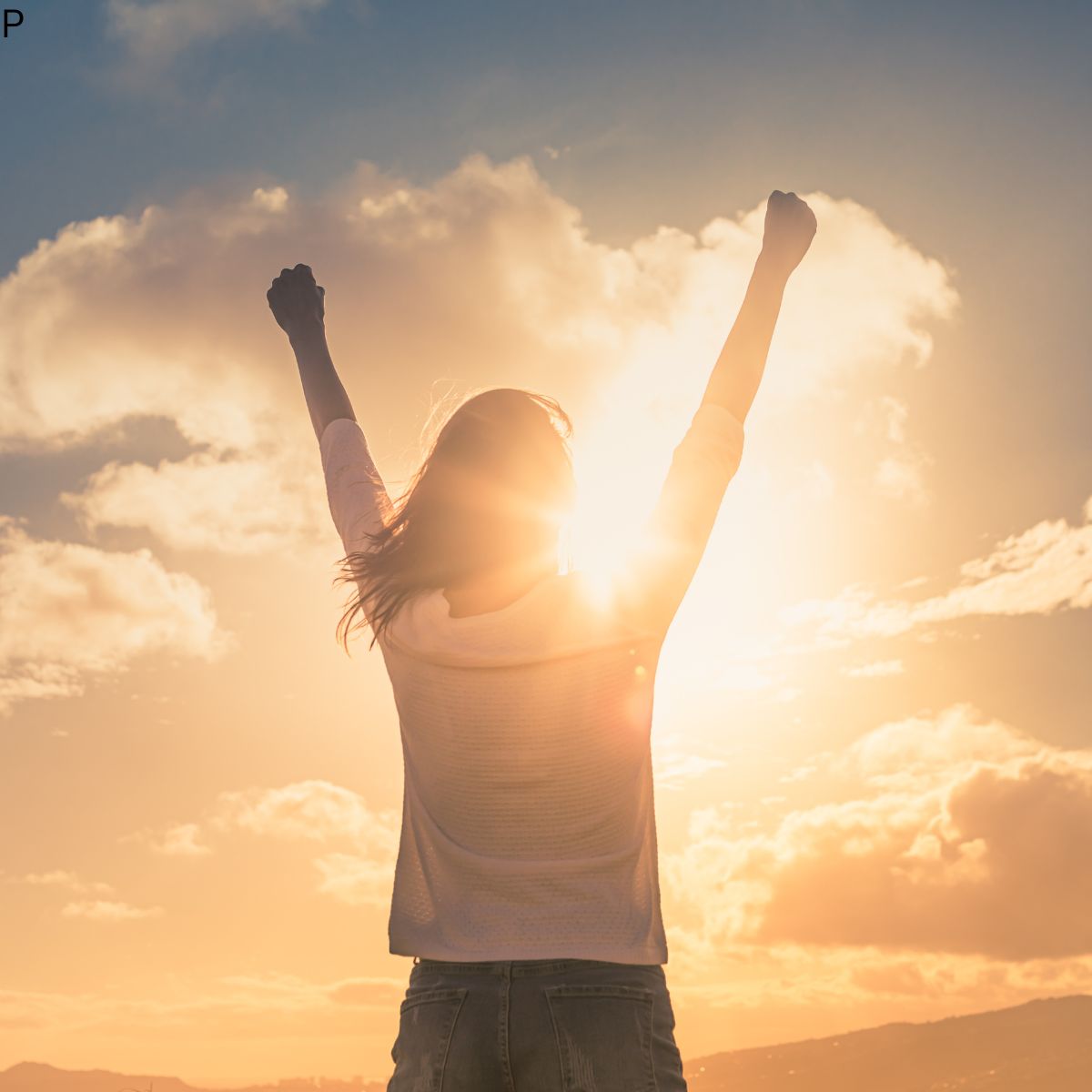 girl with arms raised in morning sunrise