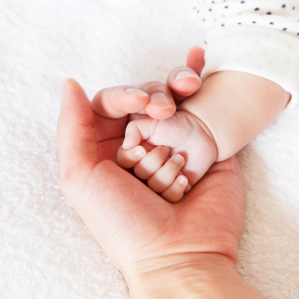 mom holding baby's hand assuring God's timing