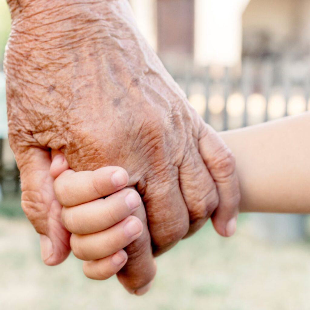 grandparent holding child's hand showing grandparents can speak life