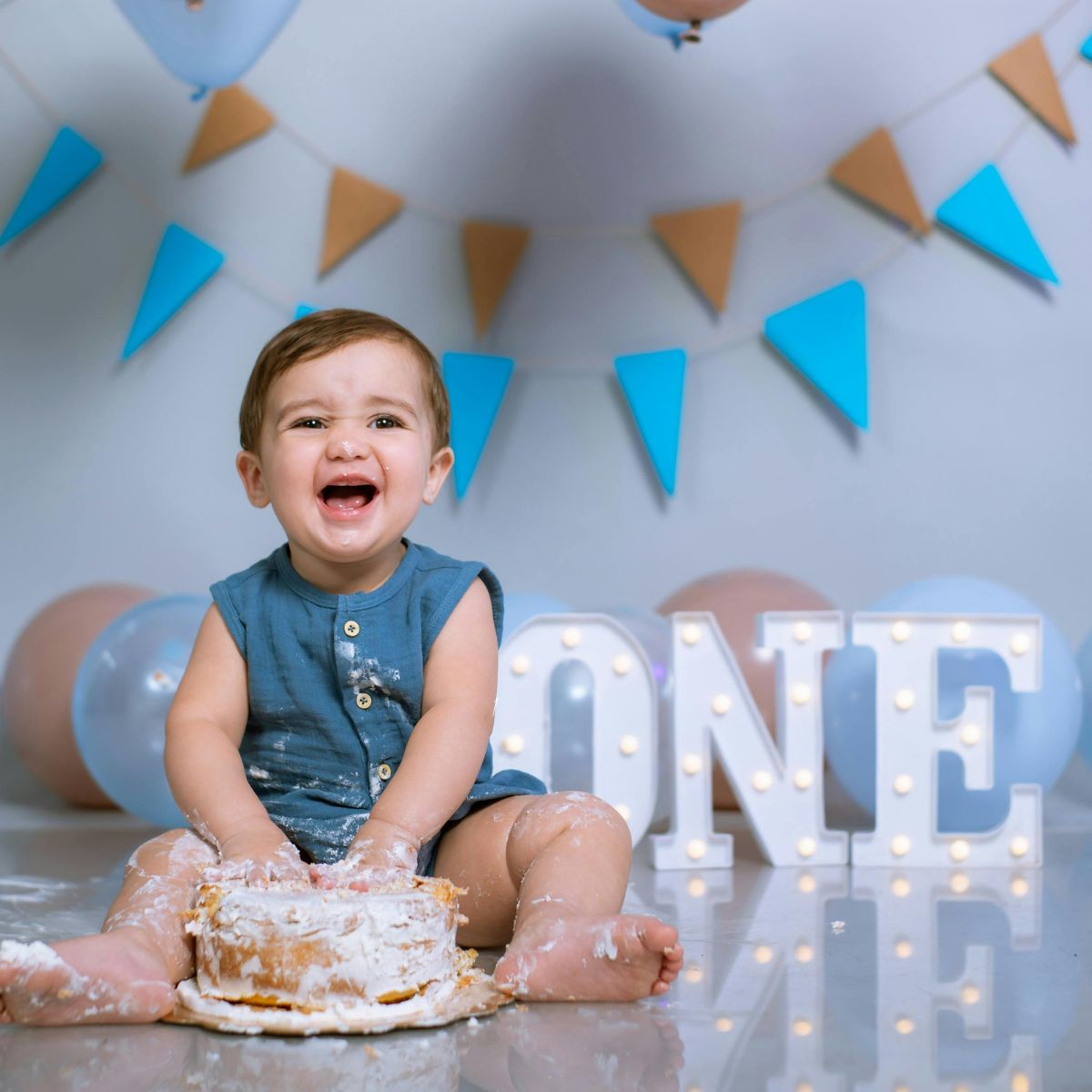 baby smashing birthday cake celebrating baby's first year